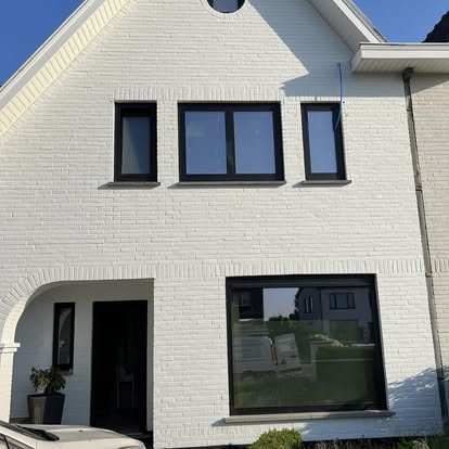 Zwarte rolluiken op een witte woning